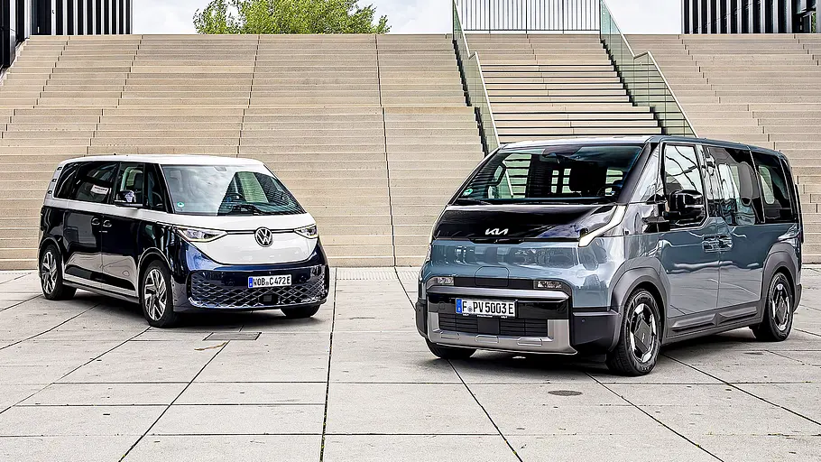 Blick von schräg vorne auf die elektrischen Kleinbusse VW ID. Buzz und Kia PV5.