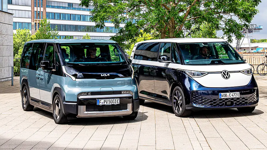 Blick von schräg vorne auf die elektrischen Kleinbusse Kia PV5 und VW ID. Buzz.