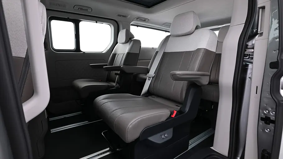 Kia PV7 Passenger Blick durch die geöffnete linke Schiebetüre in den Fahrgastraum des Kia PV7 Passenger.