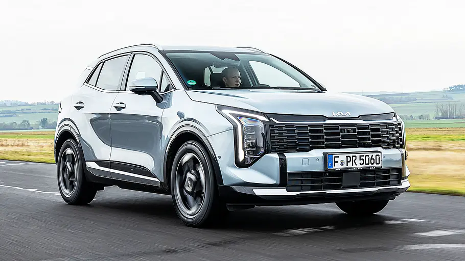 Blick von schräg vorne auf den fahrenden Kia Sportage.