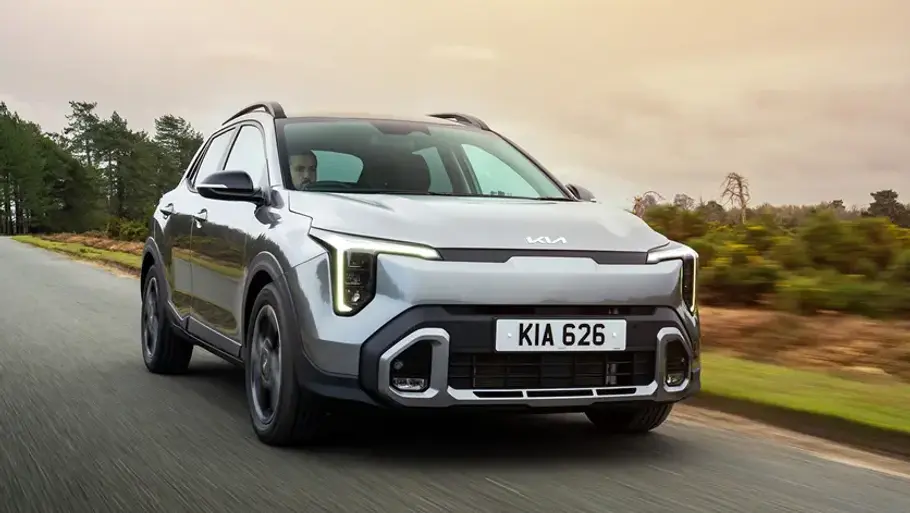 Kia Stonic Facelift Kia Stonic (2026) fährt auf einer Landstraße, Ansicht von vorne rechts.