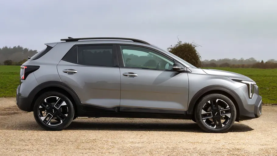 Kia Stonic Facelift Kia Stonic (2026) steht auf einem Schotterplatz, Ansicht von der rechten Seite.