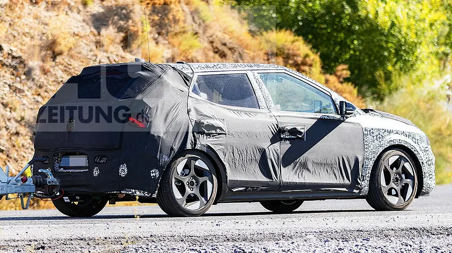 Blick von schräg hinten auf den fahrenden Erlkönig des Hyundai i20 (2026).