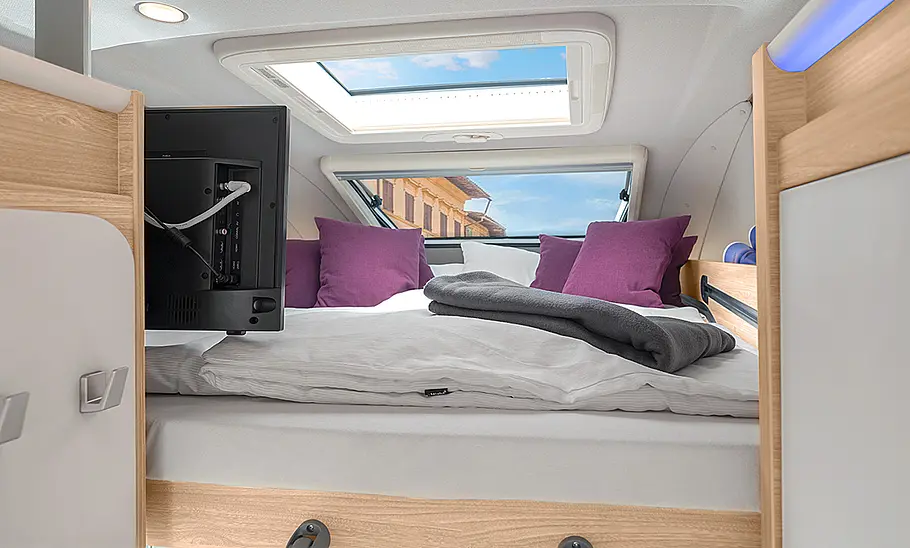 Knaus Boxlife Pro XL (2024) Das ausgefahrene Schiebebett im Hochdach des Knaus Boxlife Pro XL (2024) aus dem Küchenbereich heraus fotografiert.