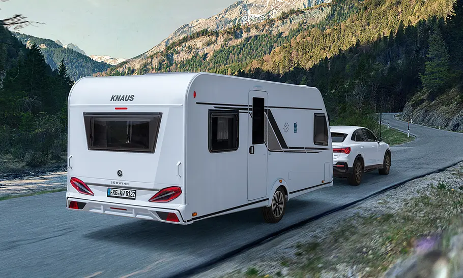 Knaus Südwind 60 Years (2024) Knaus Südwind 60 Years (2024) wird von einem Pkw auf einer Straße in den Bergen gezogen