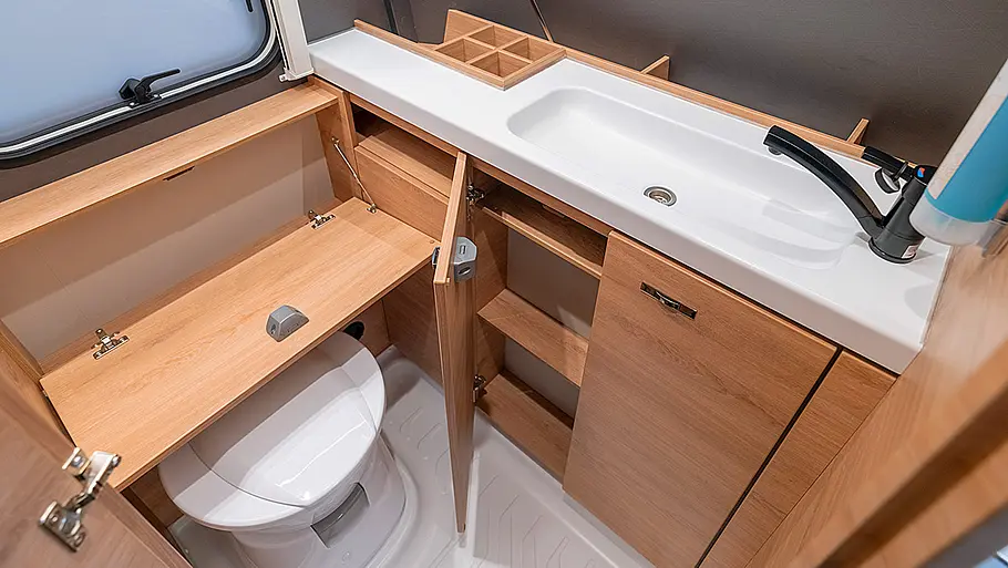  Ansicht des Badezimmers des Knaus Yaseo 340 PX mit geöffneten Verstaumöglichkeiten.