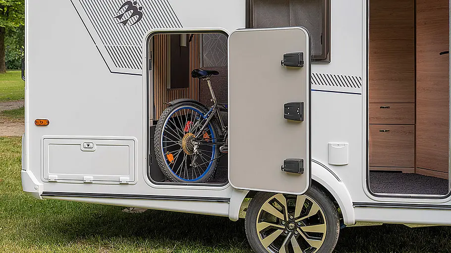 Ansicht der Garagenluke an der rechten Fahrzeugseite des Knaus Yaseo 340 PX. Ein Fahrrad ist durch die geöffnete Klappe zu sehen.