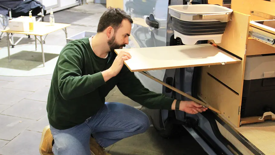 Ein Mann baut den Tisch auf.
