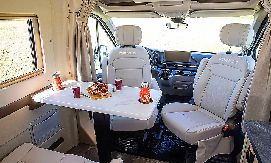 Neuer La Marca SAIC Maxus RV9 (2025) Die Dinette des La Marca SAIC Maxus RV9 (2025) mit Blick auf die gedrehten Vordersitze.