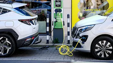 Zwei Fahrzeuge an einer Ladesäule, ein Fahrzeug ist angeschlossen. - Foto: Imago