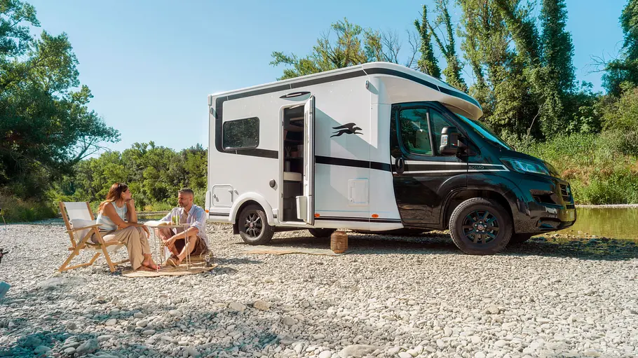Laika Kosmo L 105 Der Laika Kosmo L 105 statisch von schräg vorne rechts. Zwei Personen sitzen an einem Tisch vor dem Wohnmobil.