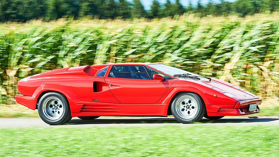Lamborghini Countach Der Lamborghini Countach fahrend von der Seite fotografiert.
