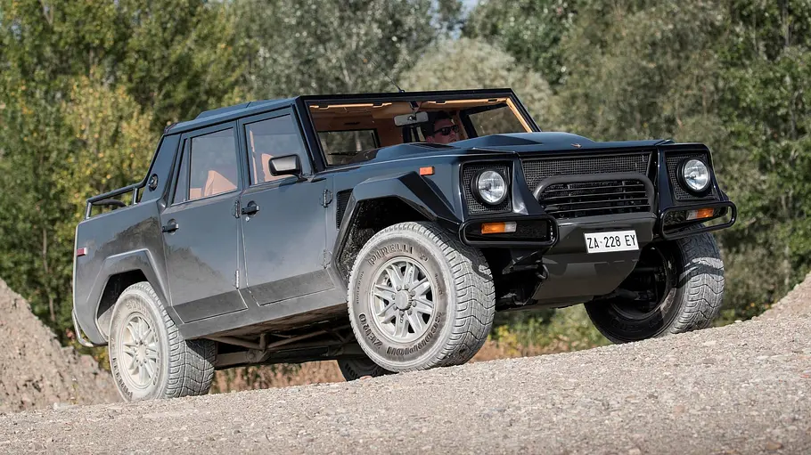 Der Lamborghini LM002 steht auf Schotter, von vorne rechts fotografiert.
