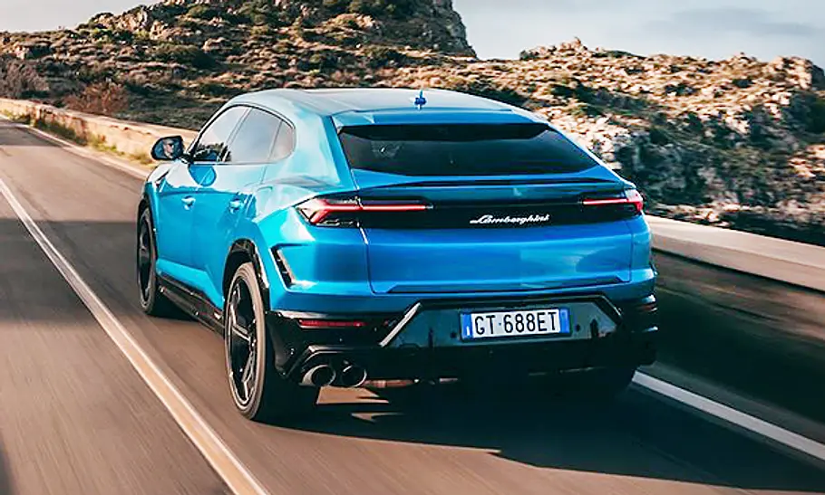 Lamborghini Urus SE (2024) Der Lamborghini Urus SE (2024) bei der Fahrt über eine Landstraße von hinten fotografiert.