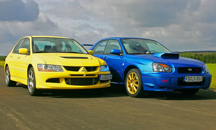 Mitsubishi Lancer Evo VIII/Subaru Impreza WRX STI Mitsubishi Lancer Evo VIII und Subaru Impreza WRX STI fahrend von schräg vorne.