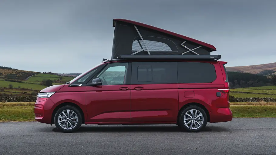 Leerer VW Multivan Camper aus Großbrittanien Der VW Multivan Camper von VW UK im Profil von links mit geöffnetem Aufstelldach.