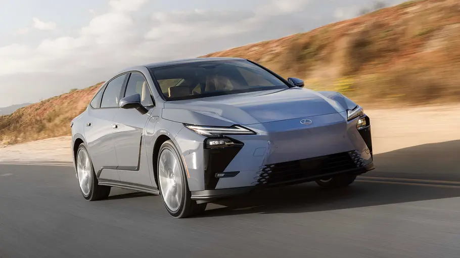 Der Lexus ES fährt auf einer Straße vor einer Düne, von vorne fotografiert.