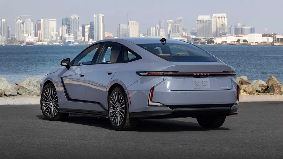 Der Lexus ES steht vor einem Gewässer und einer Skyline, von hinten links fotografiert.