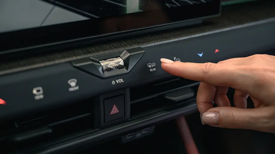 Lexus NX Facelift Eine Hand bedient die Touchflächen unter dem Zentralbildschirm im Lexus NX Facelift.