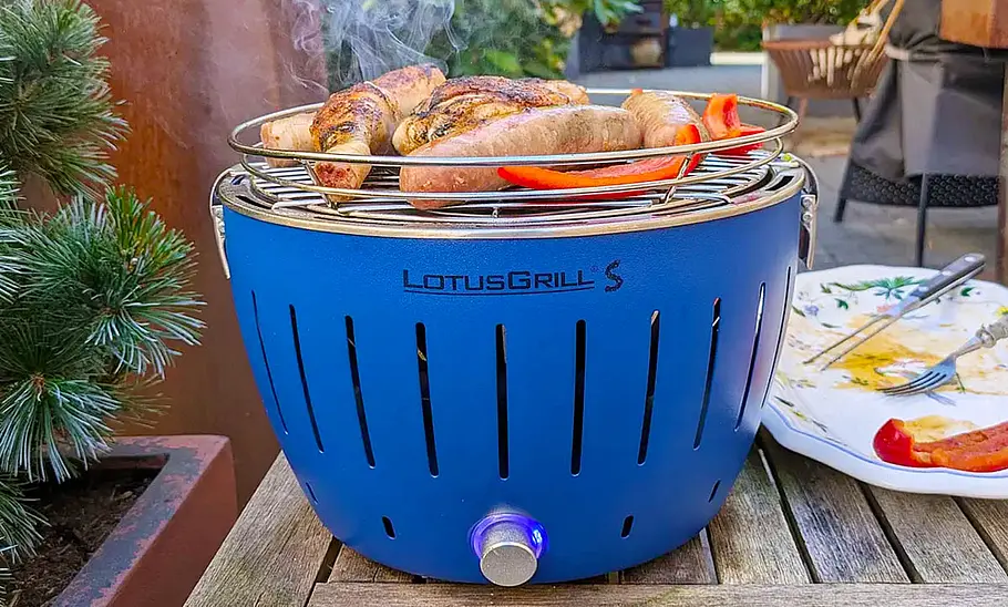 LotusGrill S Der LotusGrill S mit aufgelegten Speisen von vorne fotografiert.