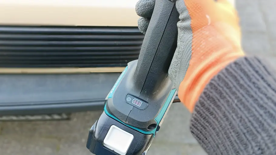 Makita Akku-Flex DGA504 Die Nahaufnahme zeigt den Makita Akku-Flex DGA504 in der Hand eines Testers.