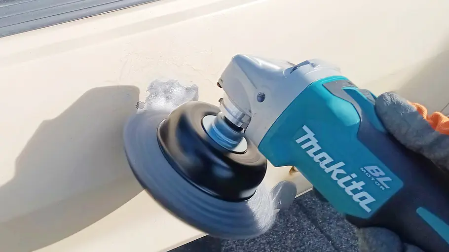 Makita Akku-Flex DGA504 Die Detailaufnahme zeigt die Makita Akku-Flex DGA504 im Einsatz am Blech eines älteren VW Polo.