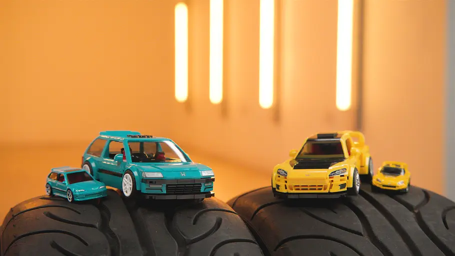 Zwei Mattel Brick Shop Honda auf Autoreifen platziert. Links der Honda Civic EF, rechts der Honda S2000.