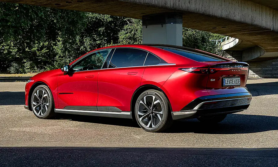 Der Mazda6e (2025) steht vor einer Brücke, fotografiert von schräg hinten.