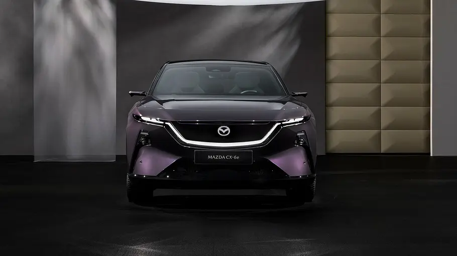 Der Mazda CX-6e (2026) stehend von vorne in Studiokulisse fotografiert.
