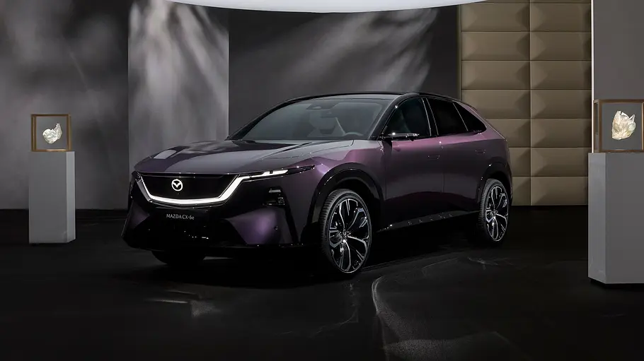 Der Mazda CX-6e (2026) stehend von schräg vorne in Studiokulisse fotografiert.