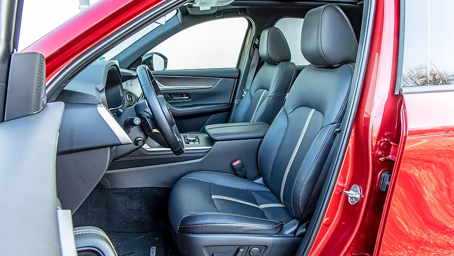 Blick durch die geöffnete Fahrertüre auf die Vordersitze des Mazda CX-60 e-Skyactiv D 254 AWD.