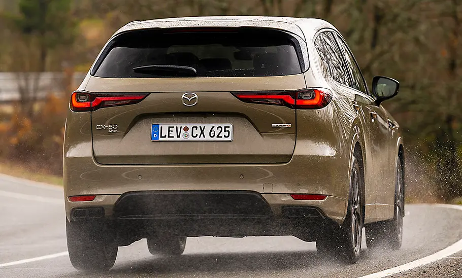 Mazda CX-60 (2025) Der Mazda CX-60 (2025) fahrend von schräg hinten fotografiert.