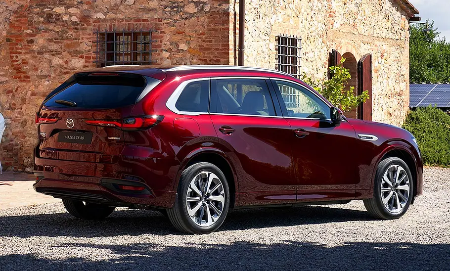 Mazda CX-80 (2024); SUV, rotes Auto, sonnige Umgebung, Heckansicht, Seitenansicht