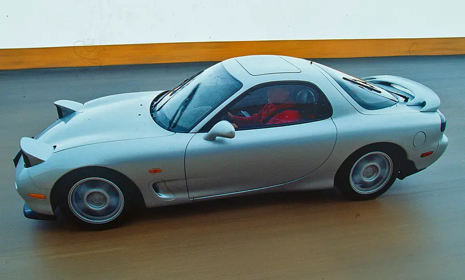 Mazda RX-7 Der Mazda RX-7 fahrend von der Seite fotografiert.