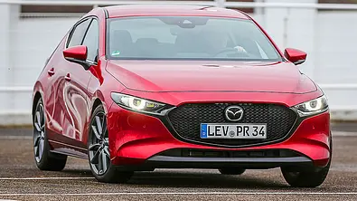 Der Mazda3 (2019) fährt auf einer Straße, von vorne rechts fotografiert. - Foto: Niklas Gotta