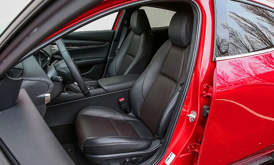 Die vorderen Sitze des Mazda3 (2019), durch die offene Fahrertür fotografiert.