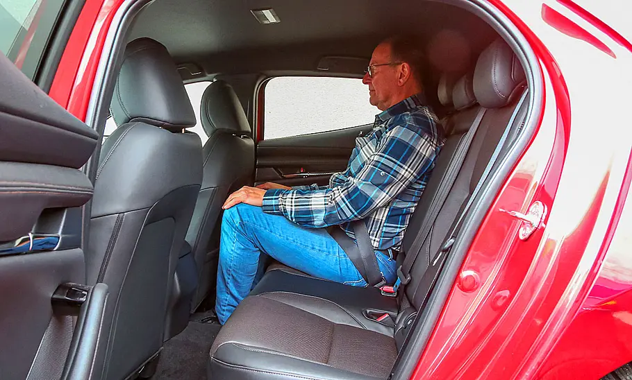 Eine Person sitzt im Fond des Mazda3 (2019).
