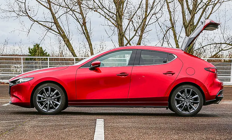 Der Mazda3 (2019), mit geöffneter Heckklappe von der linken Seite fotografiert.