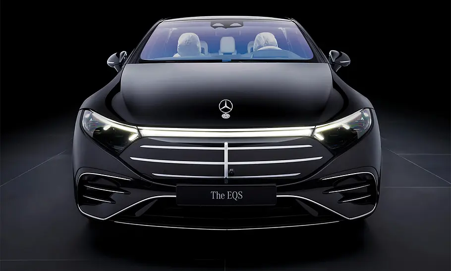 Mercedes EQS Facelift (2024) vor dunklem Hintergrund, Ansicht von vorne.