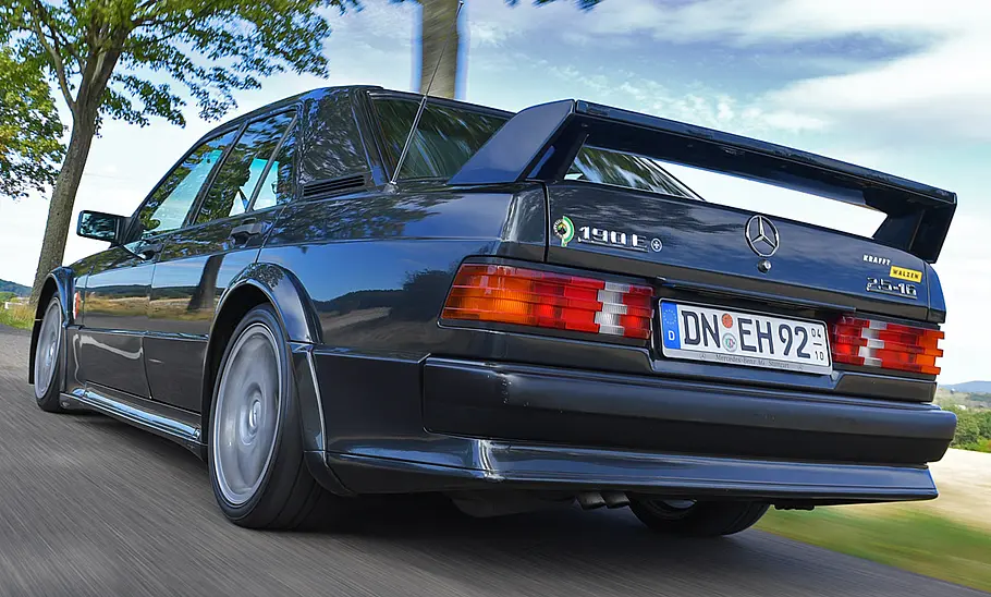 Der Mercedes 190 Evo fahrend von schräg hinten fotografiert.