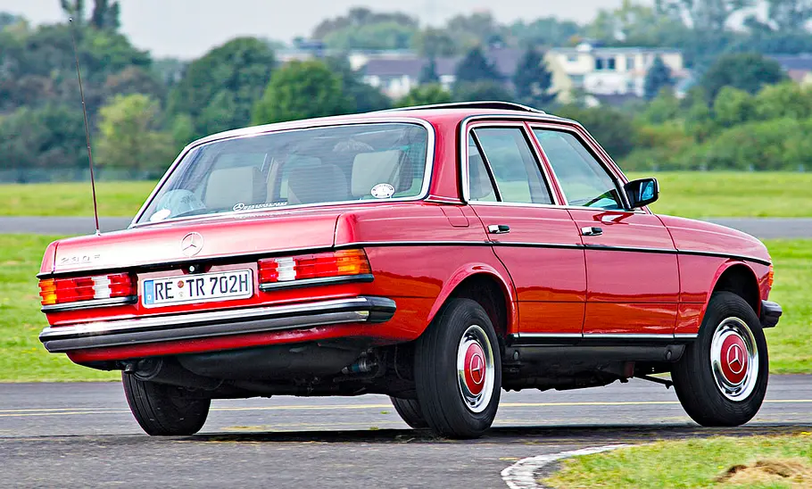 Mercedes 230 E fahrend von schräg hinten fotografiert.