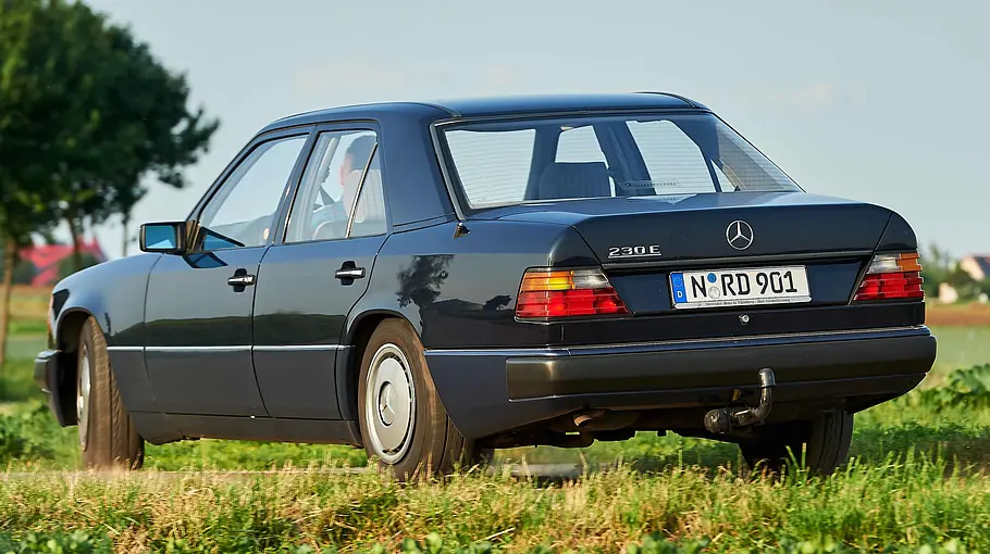 Mercedes 230 E fahrend von schräg hinten fotografiert. 