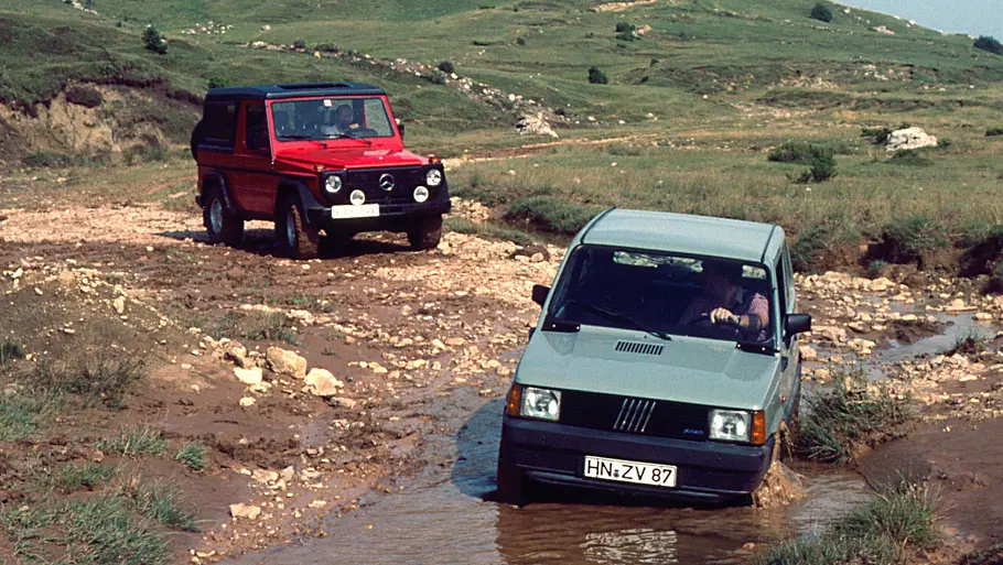 Mercedes 280 GE/Fiat Panda 4x4 fahrend von schräg vorne fotografiert. 