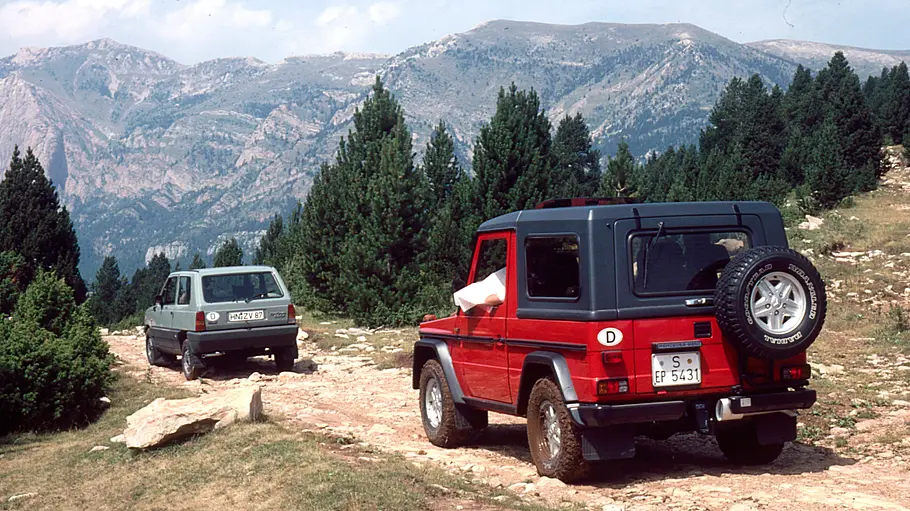 Mercedes 280 GE/Fiat Panda 4x4 fahrend von schräg hinten fotografiert. 