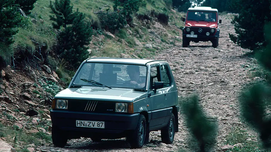 Mercedes 280 GE/Fiat Panda 4x4 fahrend von schräg vorne fotografiert. 