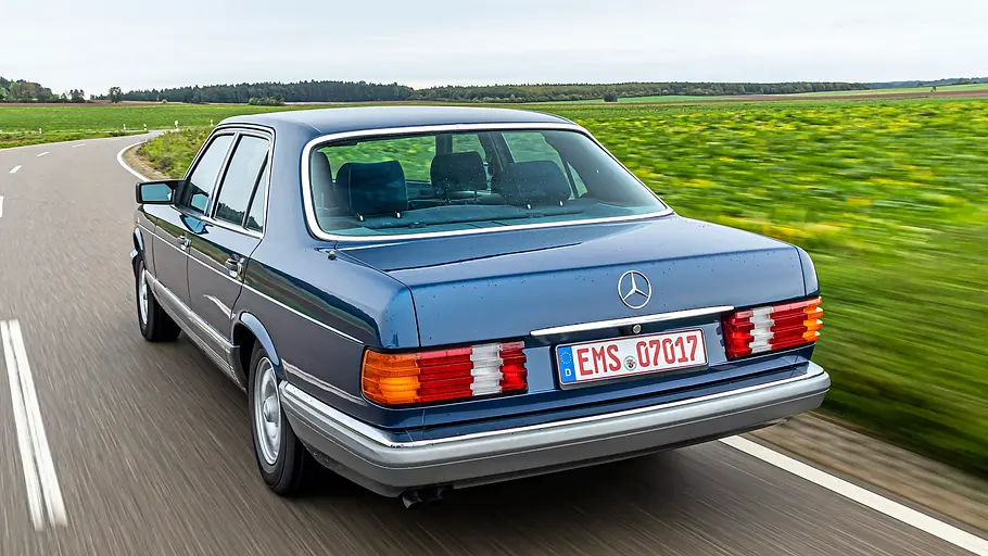 Mercedes 280 SE fahrend von schräg hinten fotografiert. 