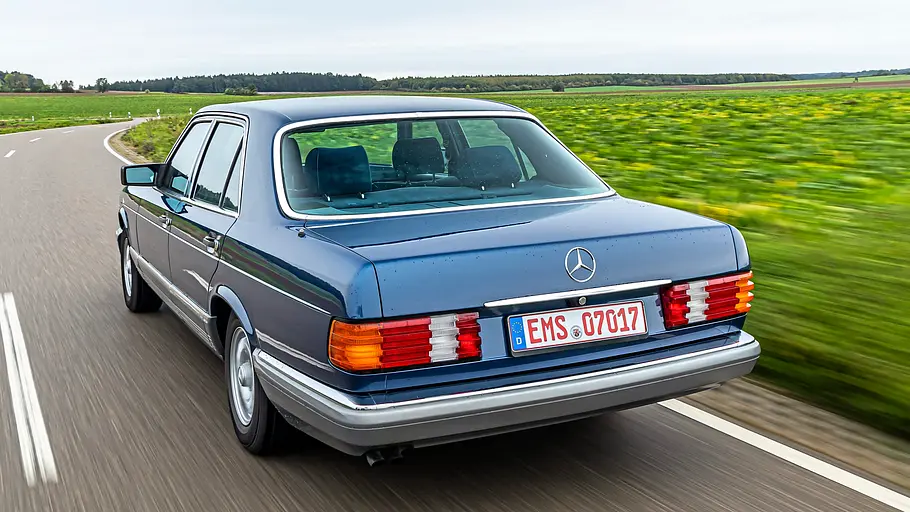 Mercedes 280 SE fahrend von schräg hinten fotografiert. 