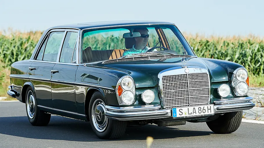 Mercedes 300 SEL 6.3 fahrend von schräg vorne fotografiert. 