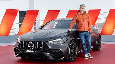 Mercedes-AMG CLE 53 Coupé (2024); statisch von vorne rechts, mit angelehnter Person - Foto: Mercedes