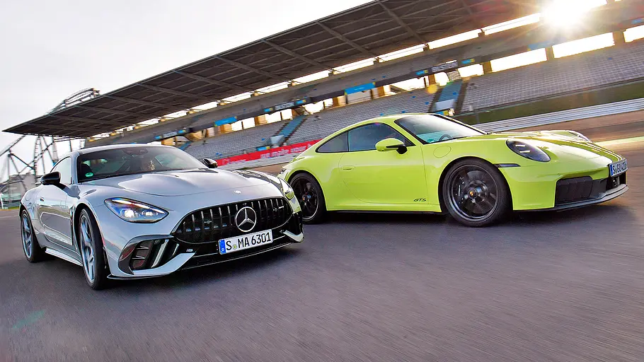 Blick von schräg vorne auf die beiden fahrenden Sportwagen Mercedes-AMG GT Pro und Porsche 911 GTS.